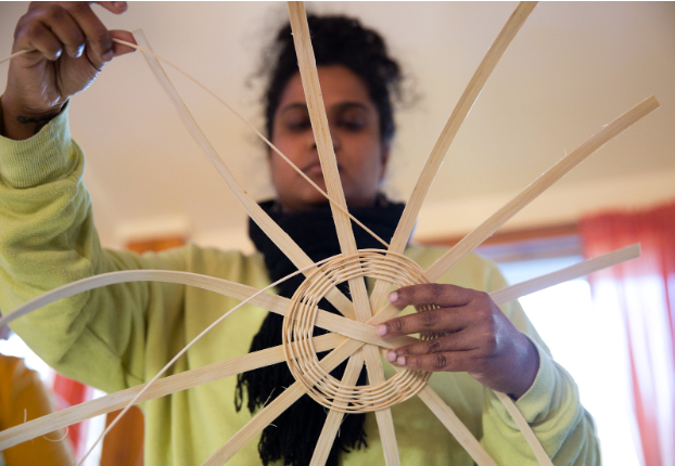 Person beginning to weave a basket.