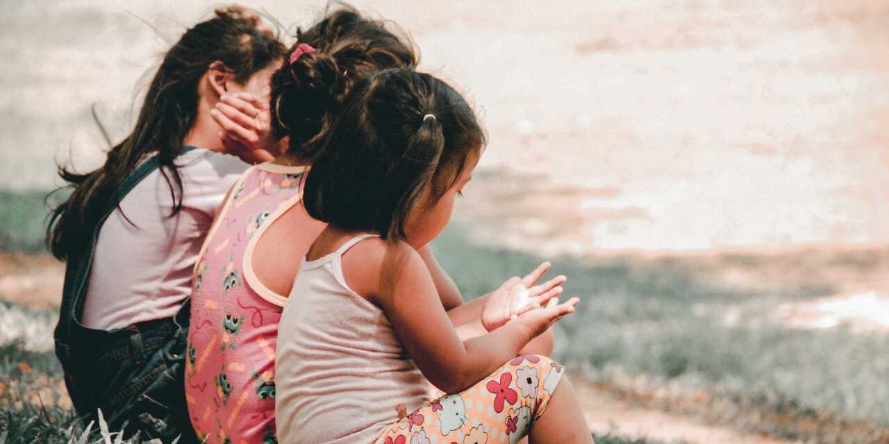 toddler girls sitting on lawn